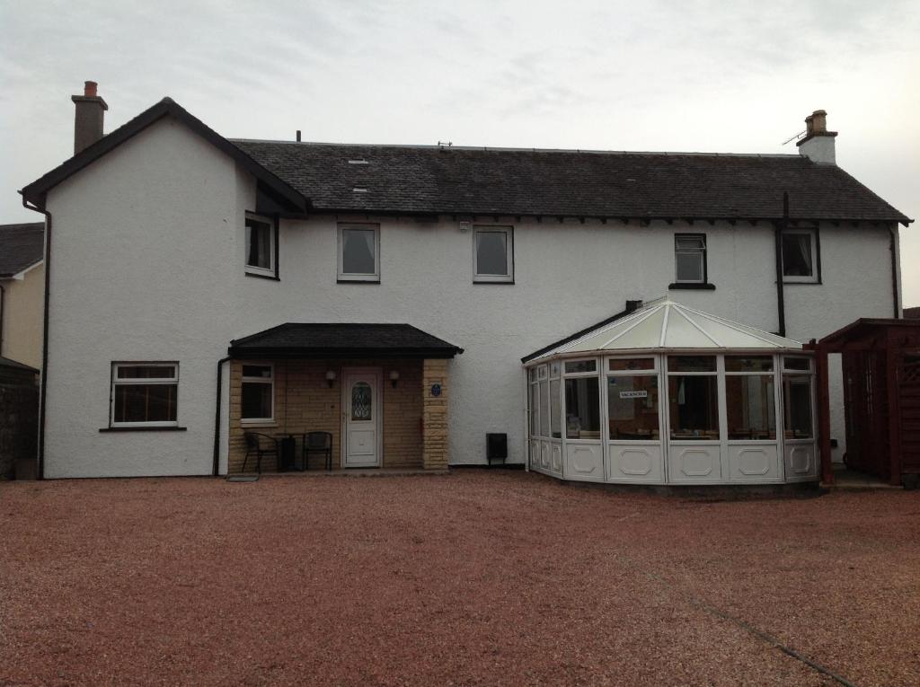 una casa bianca con una serra davanti di Whitehouse Guest House a Stirling