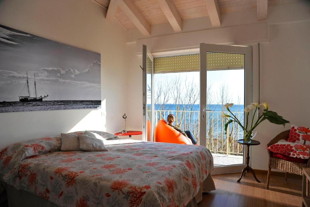a bedroom with a bed and a large window at B&B Viale Italia 22 in Follonica