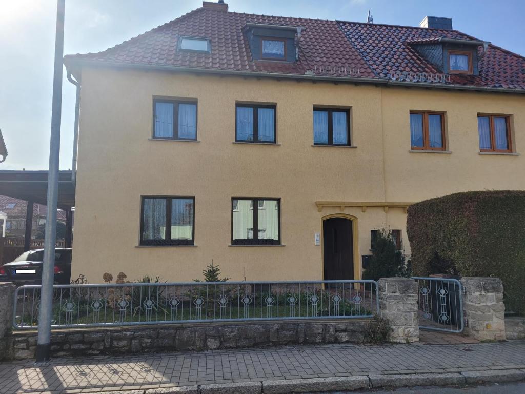 una casa amarilla con una valla delante de ella en Ferienwohnung Familie Klingohr, en Erfurt