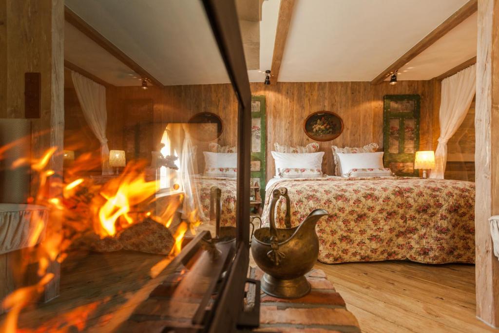 einen Kamin in einem Schlafzimmer mit einem Bett und einem Kamin in der Unterkunft Weißt Du noch - Gästehäuser & Suiten in Kühlungsborn