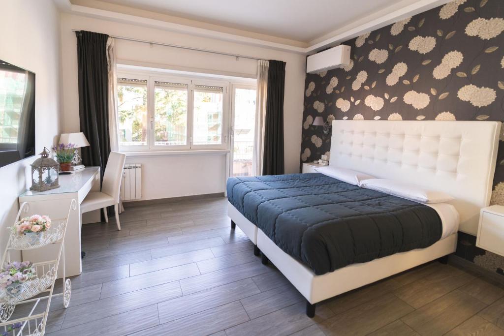 1 dormitorio con cama, escritorio y ventana en RomAntic Dreams Guest House, en Roma
