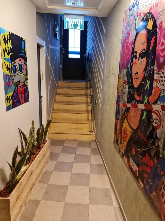 einen Flur mit Treppen und Gemälden an den Wänden in der Unterkunft SPACE ART BOUTIQUE Downtown in Jerusalem