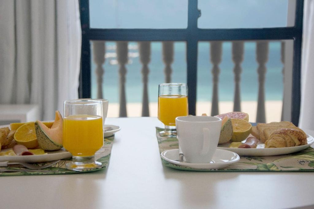 een tafel met twee borden eten en twee glazen sinaasappelsap bij Classic Flat Residence Service ap.902 in Fortaleza