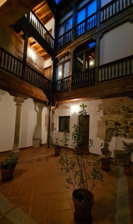a large building with a courtyard with potted plants at El Rinconcito de la Merced in Toledo