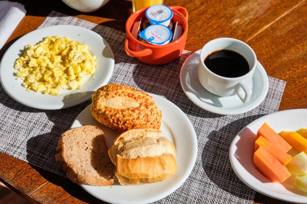 a table with plates of breakfast foods and a cup of coffee at Boutique Hotel Carpe Diem in Paraty
