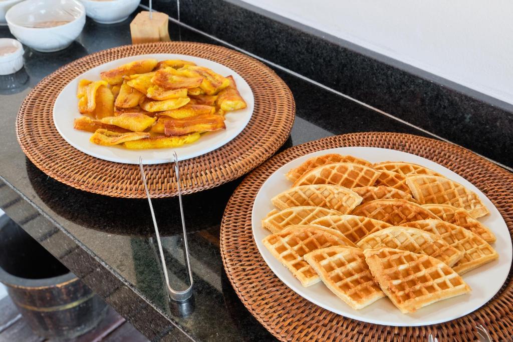 two plates of waffles and a plate of food on a counter at Boutique Hotel Carpe Diem in Paraty