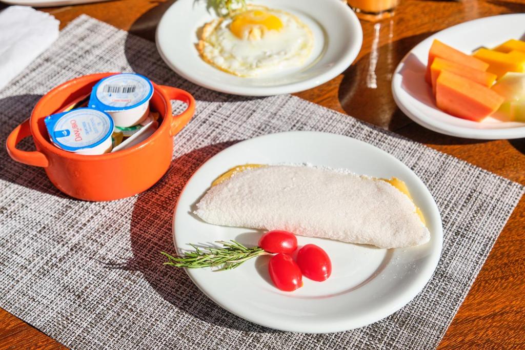 a plate of food with a sandwich and eggs and fruit at Boutique Hotel Carpe Diem in Paraty