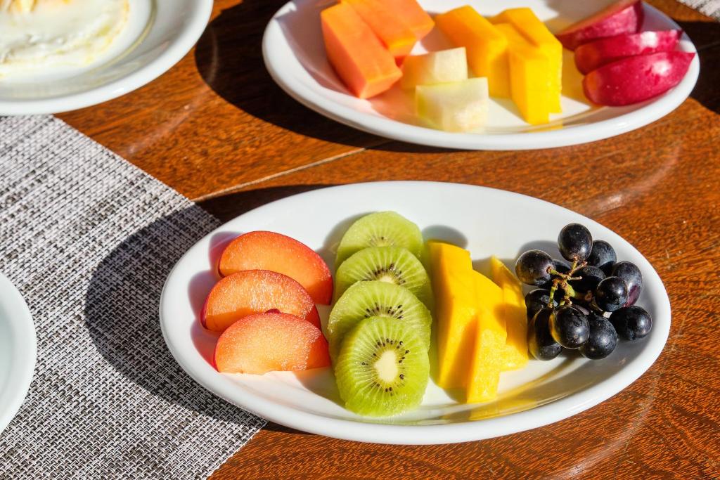 three plates of fruit on a wooden table at Boutique Hotel Carpe Diem in Paraty