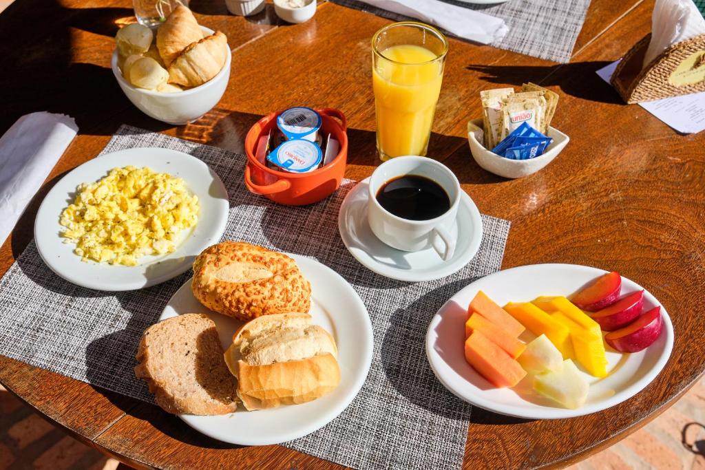 a table with plates of breakfast food on it at Boutique Hotel Carpe Diem in Paraty