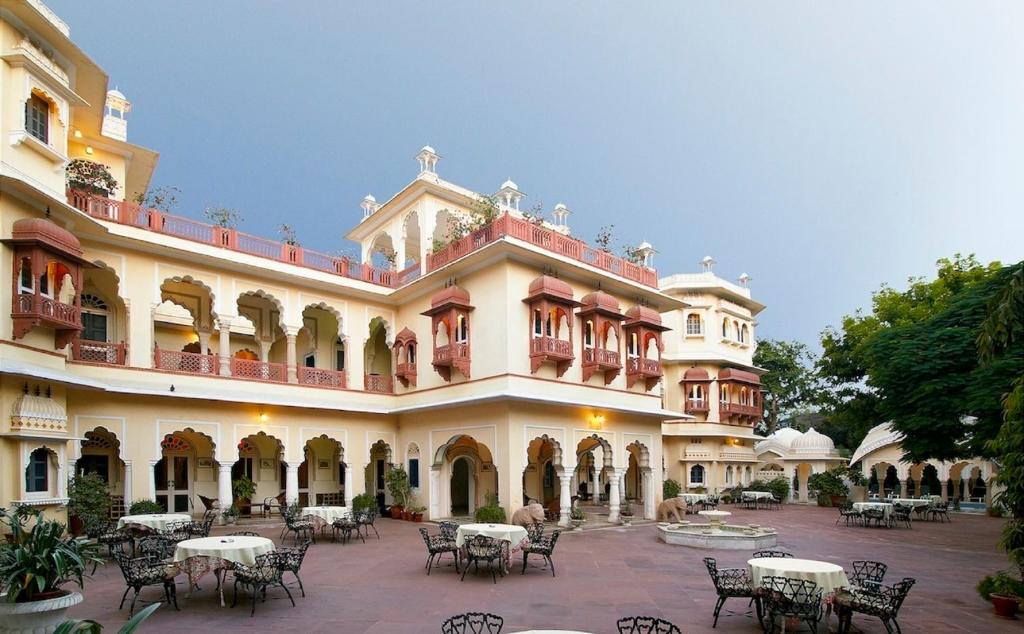 un grande edificio con tavoli e sedie in un cortile di Alsisar Haveli - Heritage Hotel a Jaipur