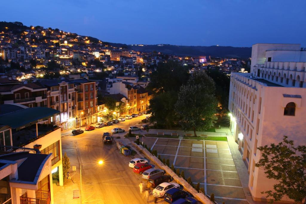 una città di notte con auto parcheggiate in strada di City Hotel a Veliko Tŭrnovo