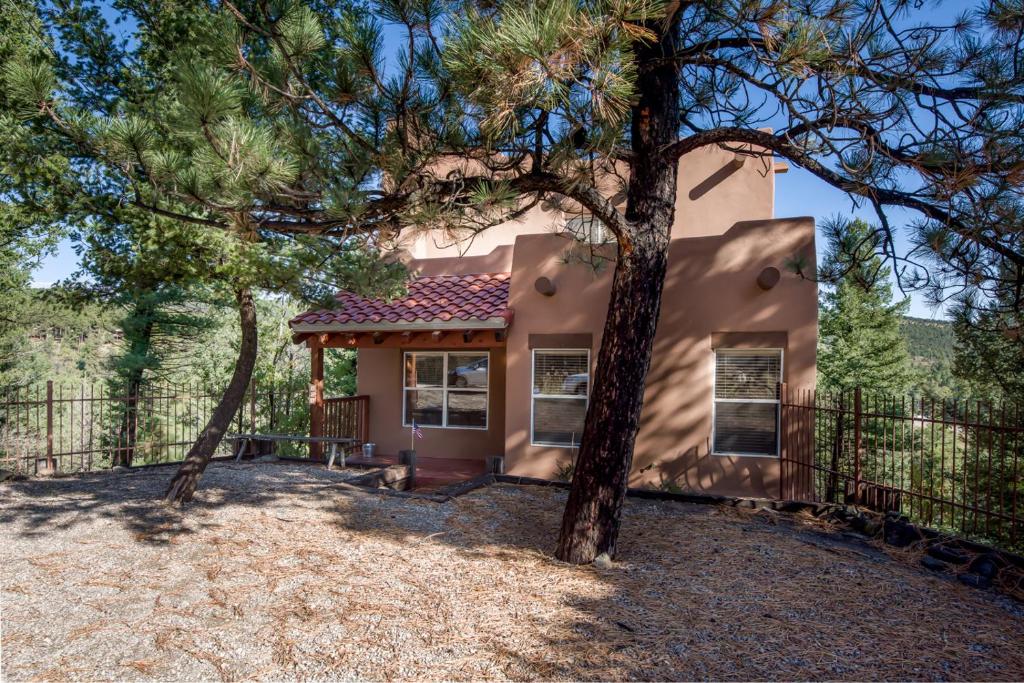 a house with trees in front of it at Adobe Hacienda, 3 Bedrooms, Sleeps 8, Gas Grill, Fenced Yard, WiFi in Ruidoso