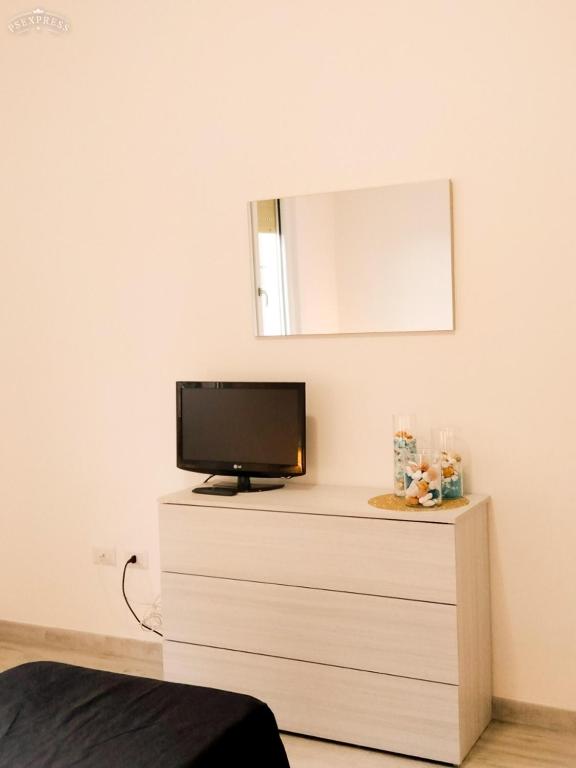 telewizor na komodzie z lustrem w obiekcie Villa Valentina w mieście Madonna dellʼAcqua
