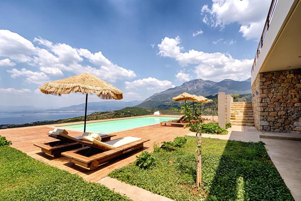 a swimming pool with two umbrellas and a swimming pool at Euphoria Estate Messinia in Avía