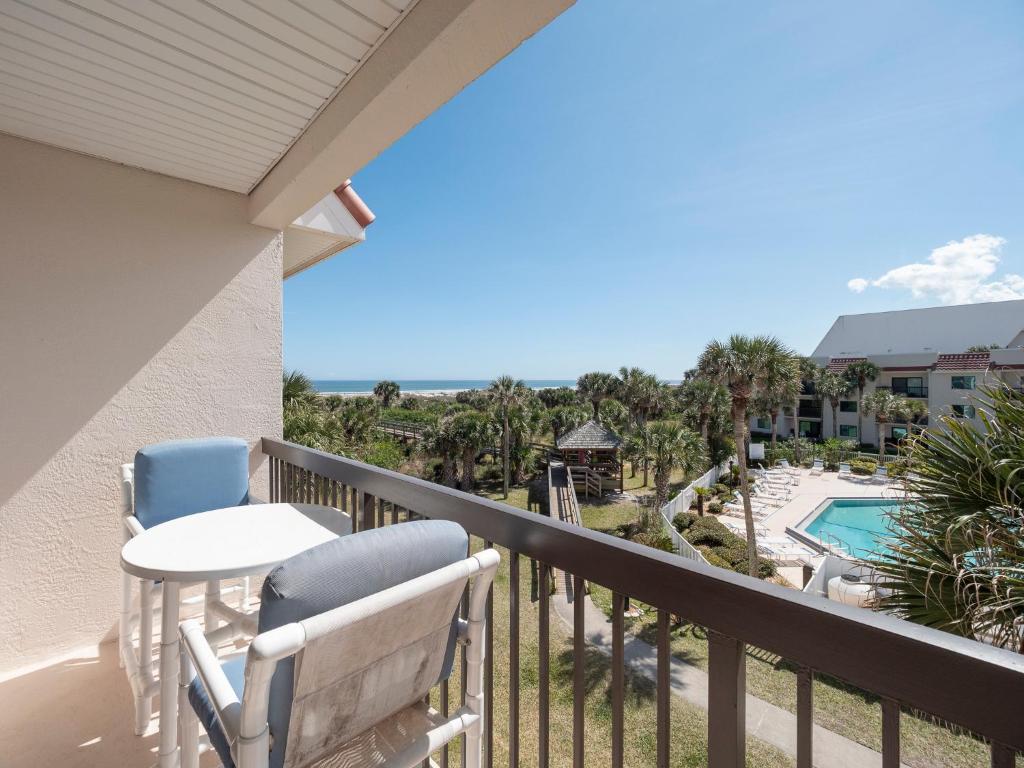 een balkon met een tafel en stoelen en een zwembad bij Ocean Village Club Q36, 3rd Floor, 2 Bedrooms, Pet Friendly, Sleeps 6 in St. Augustine