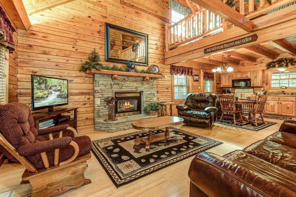 a living room with a fireplace in a log cabin at Return To Me, 3 Bedrooms, Sleeps 9, Pool Table, Hot Tub, Gas Fireplace in Sevierville