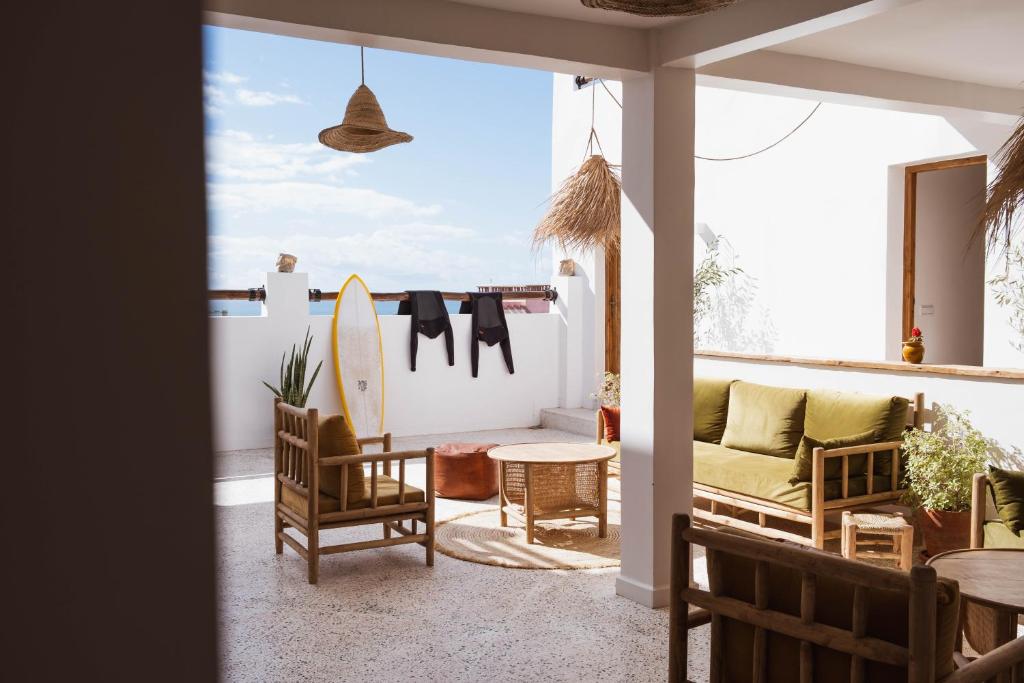 a living room with a couch and a surfboard at SwellHouse in Tamraght Ouzdar
