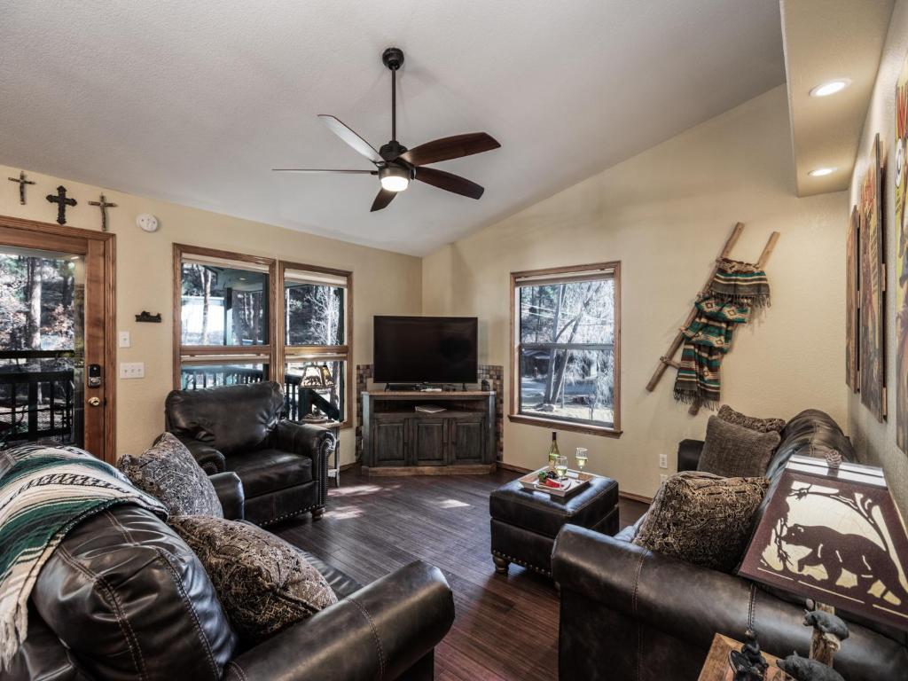 un soggiorno con mobili in pelle e una TV a schermo piatto di Midtown Riverfront 1 a Ruidoso