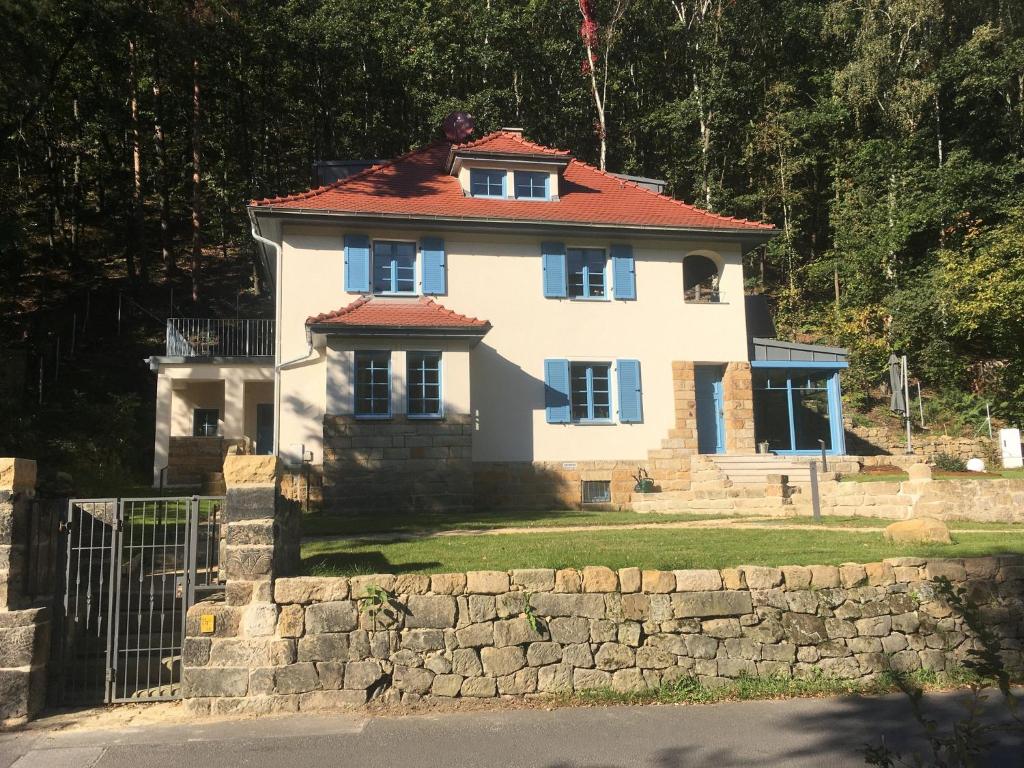 ein großes weißes Haus mit rotem Dach in der Unterkunft Prima Klima Villa - Ferienwohnung Steinbrecher in Struppen