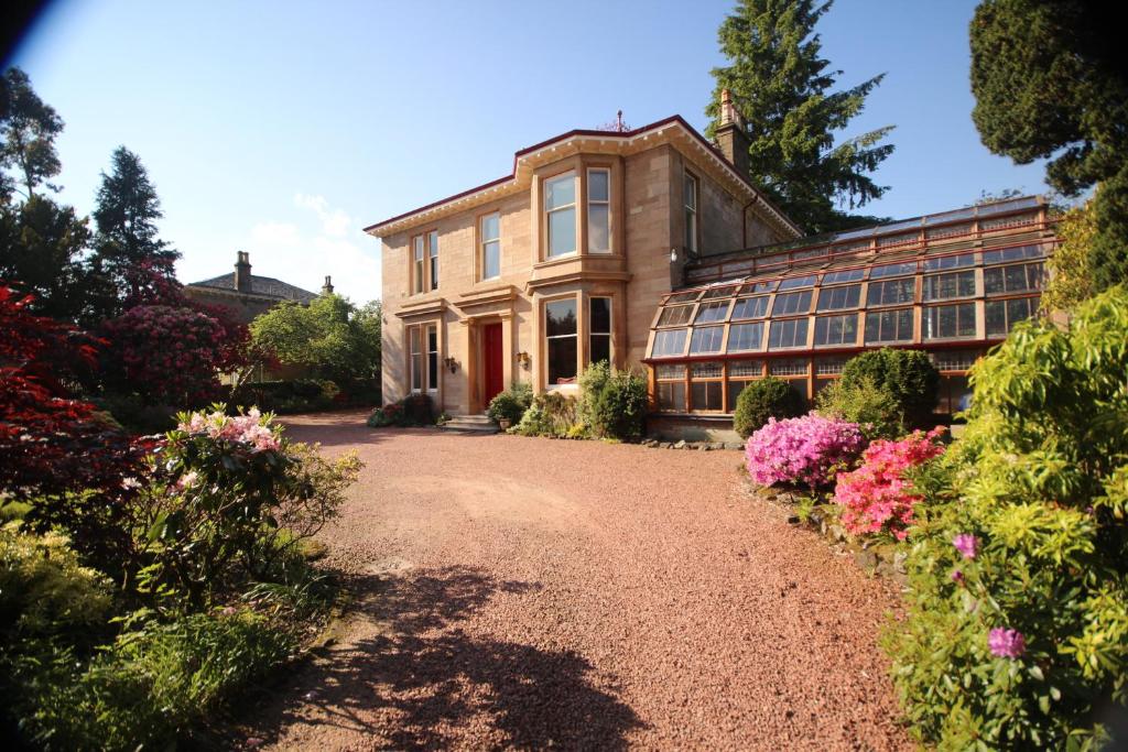 uma casa com flores em frente a uma entrada em Moorlands em Helensburgh