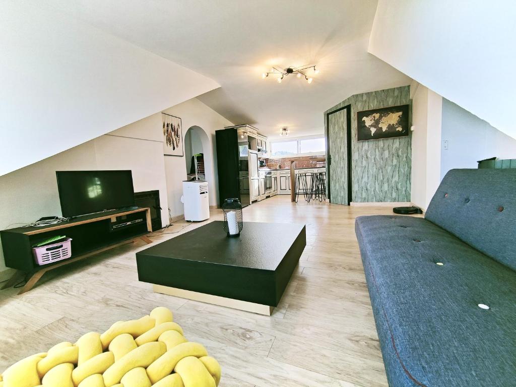 ein Wohnzimmer mit einem Sofa und einem Tisch in der Unterkunft Appartement à l'entrée des trois vallées des Pyrénées - 50m2 