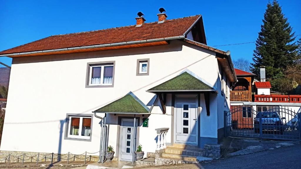 Casa blanca con techo marrón en Apartman Adna, en Kulen Vakuf