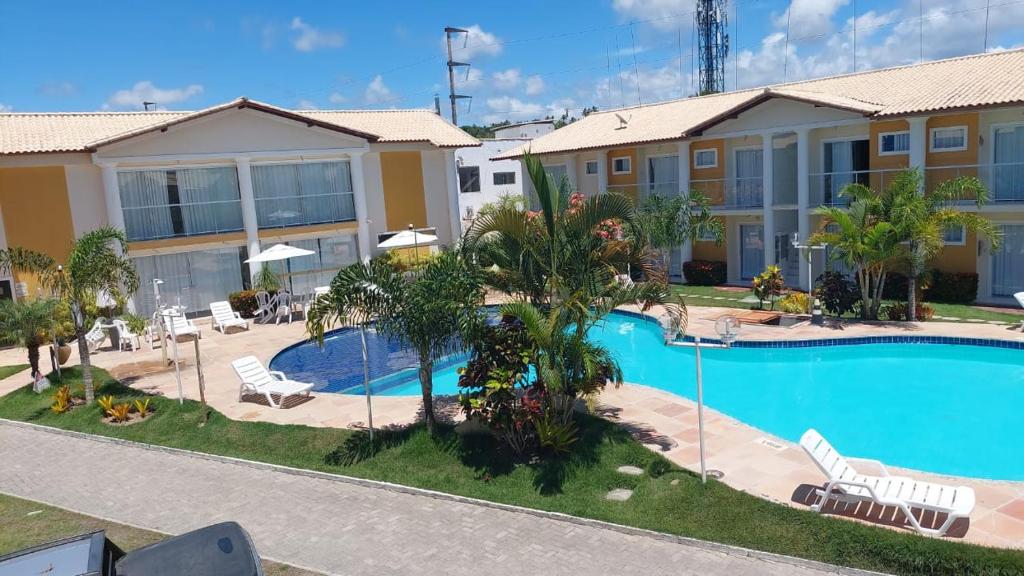 een villa met een zwembad in een resort bij Residencial Mont Carmelo in Porto Seguro