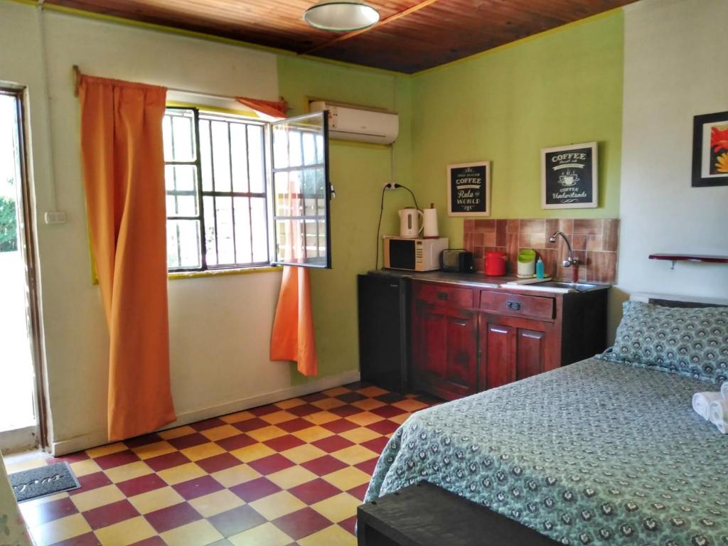 1 dormitorio con 1 cama y lavamanos y cocina en Apartamento Monoambiente Independiente en Salto Ciudad, en Salto