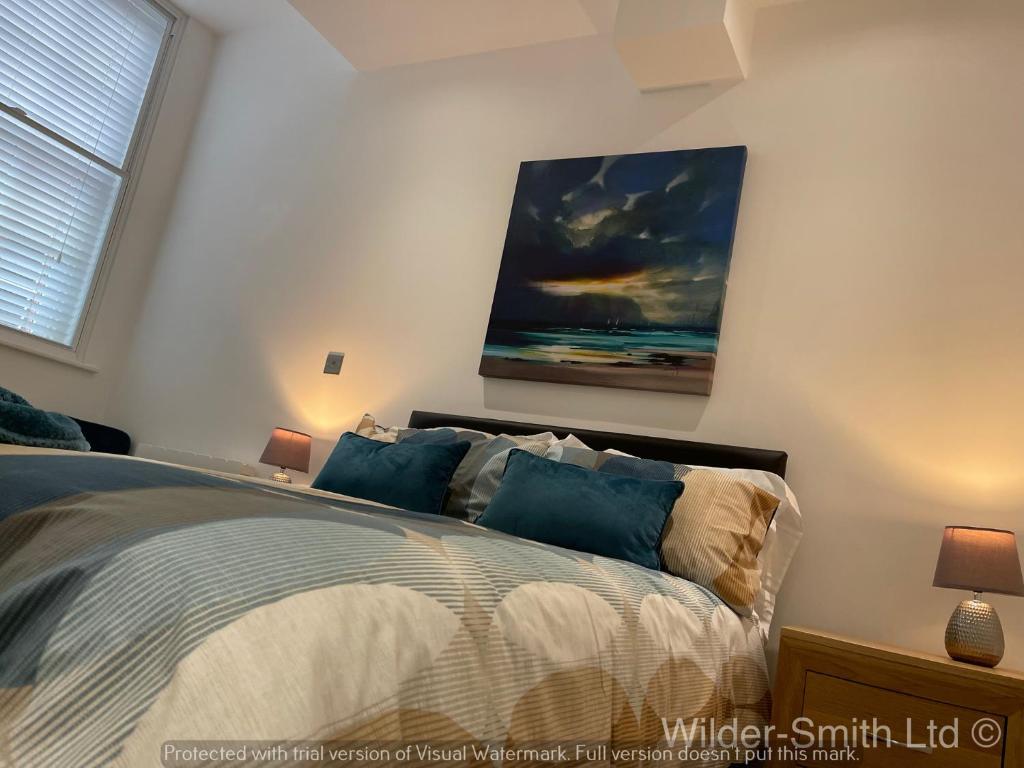 a bedroom with a bed with a painting on the wall at Stylish 2-Bed Luxury Apartment in Nottingham City in Nottingham