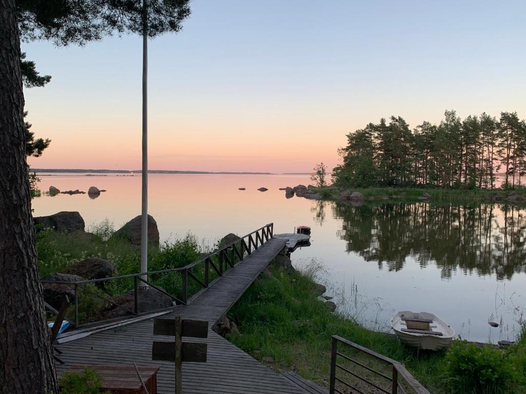 a boardwalk leading to a lake with a boat on it at Vänvik Pyhtää in Siltakylä