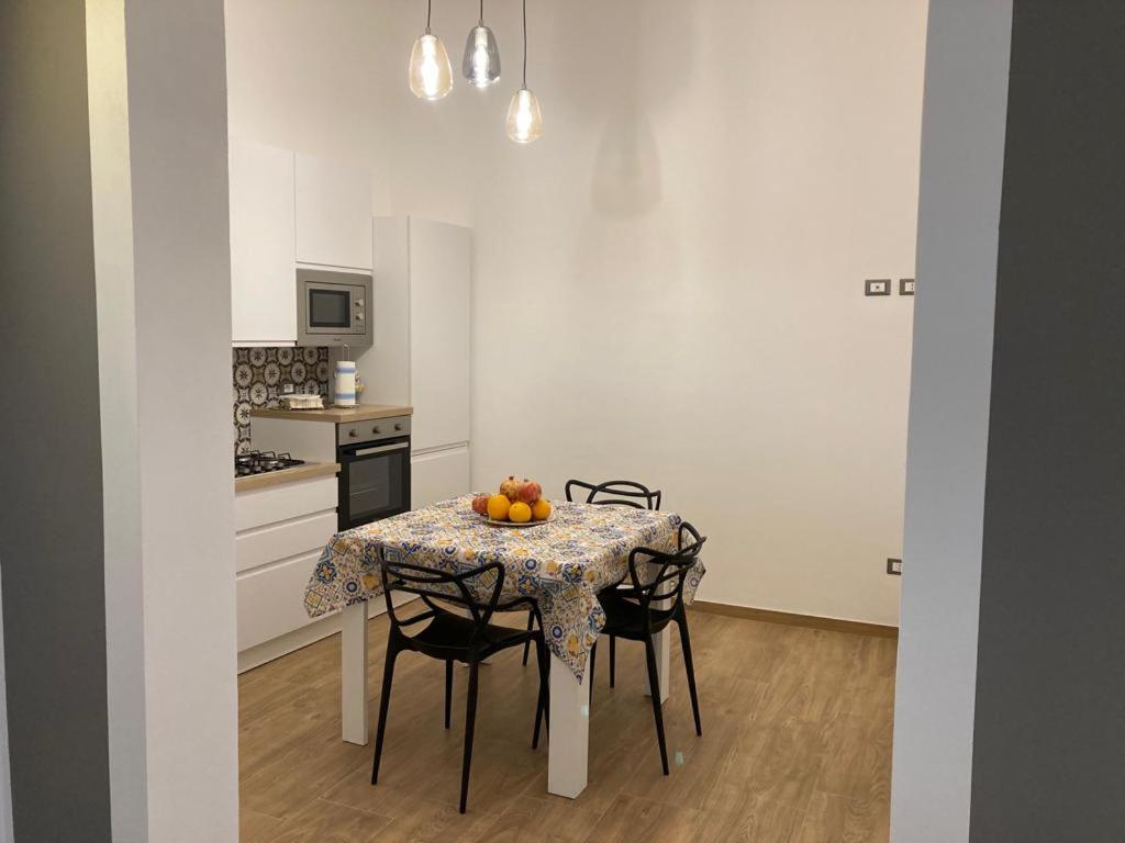 a kitchen with a table and chairs with fruit on it at Casa Vacanze al Trenta3 in Marsala