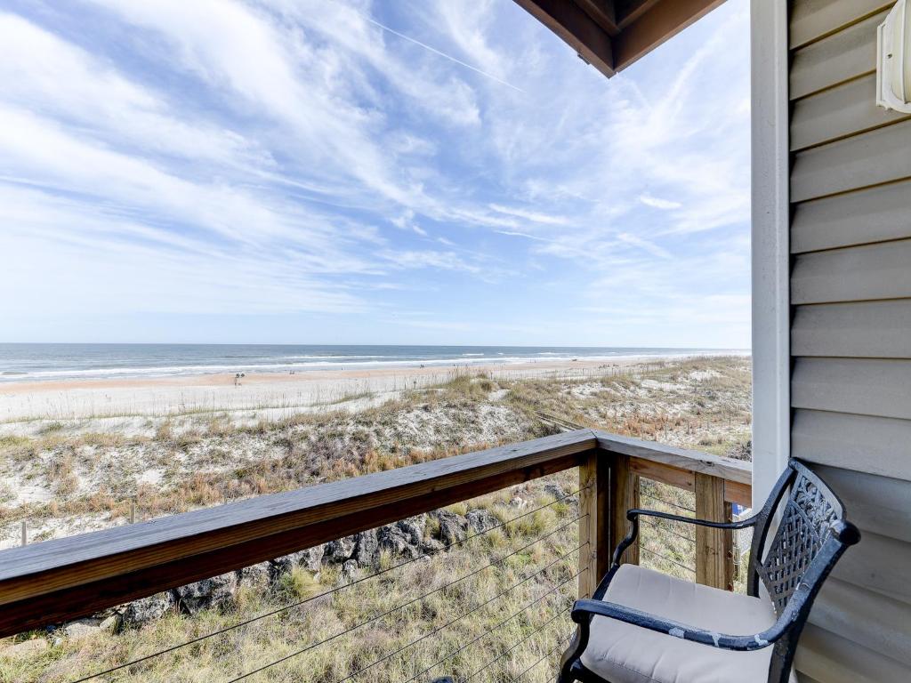 a porch with a chair and a view of the beach at Surfside Six E, 2 Bedrooms, Ocean Front, Sleeps 6, Wireless Internet in Saint Augustine