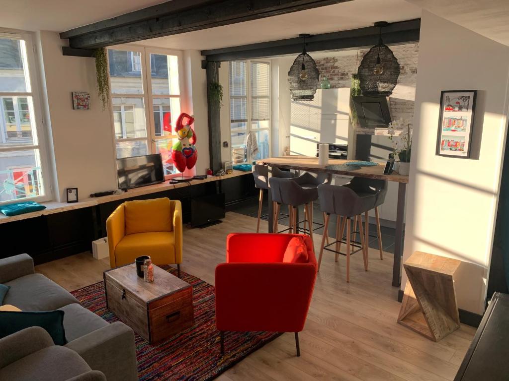 een woonkamer met een bank, stoelen en een tafel bij La Loge des Artistes in Honfleur