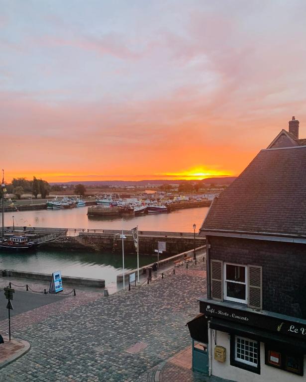 un coucher de soleil sur un port avec des bateaux dans l'eau dans l'établissement La Loge des Artistes, à Honfleur