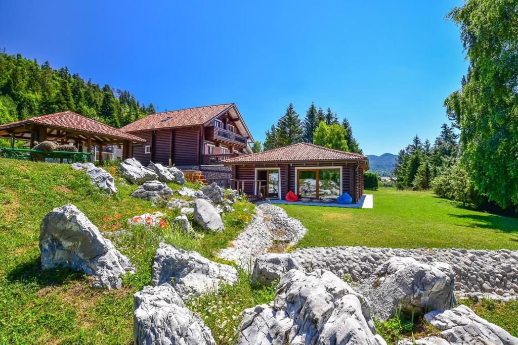 ein Haus auf einem Feld mit Felsen davor in der Unterkunft Luksuzna kuća za odmor RINA in Fužine