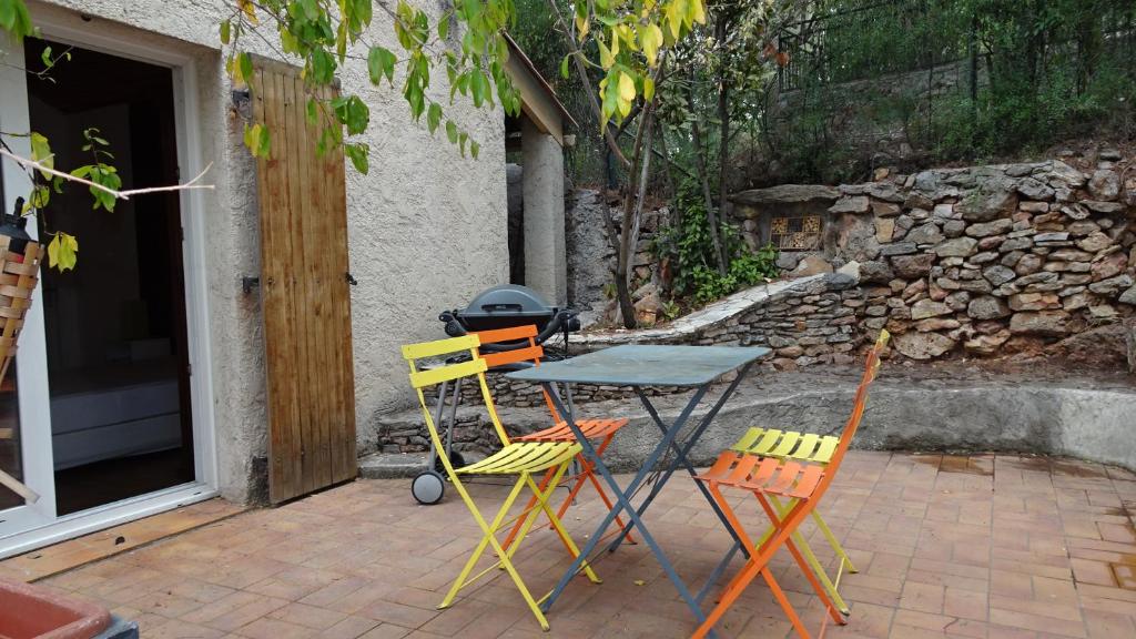 stół i 4 krzesła na patio w obiekcie le paradis des oiseaux w mieście Tulon