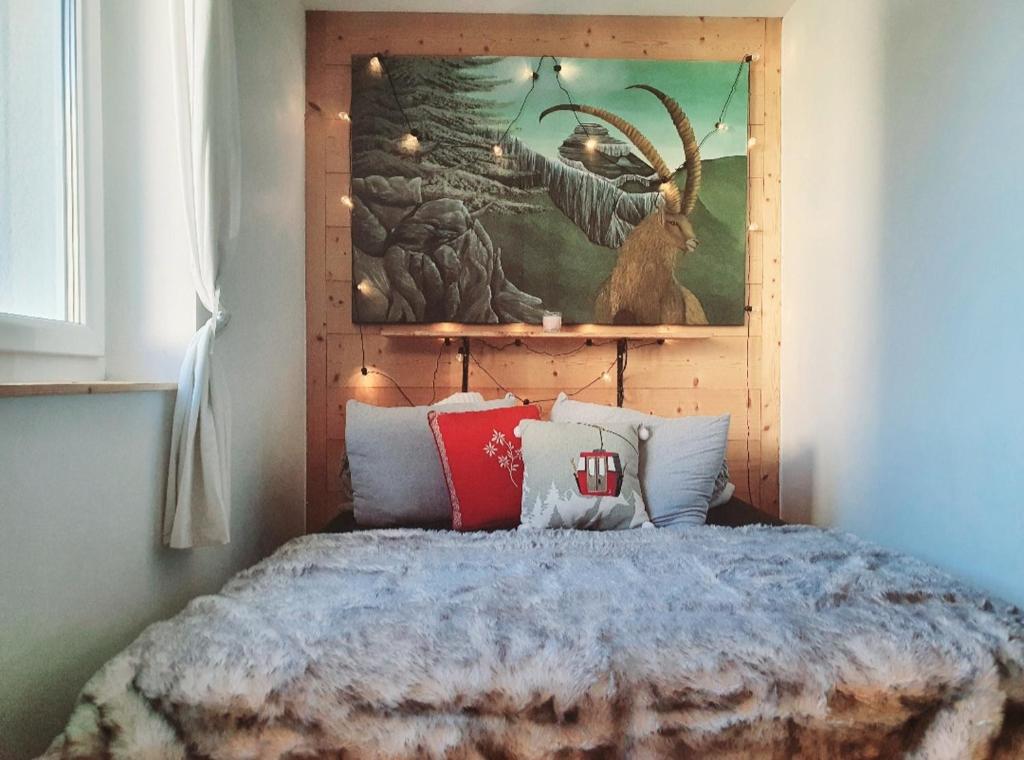 - une chambre avec un lit orné d'une peinture murale dans l'établissement Heidi, à Leysin