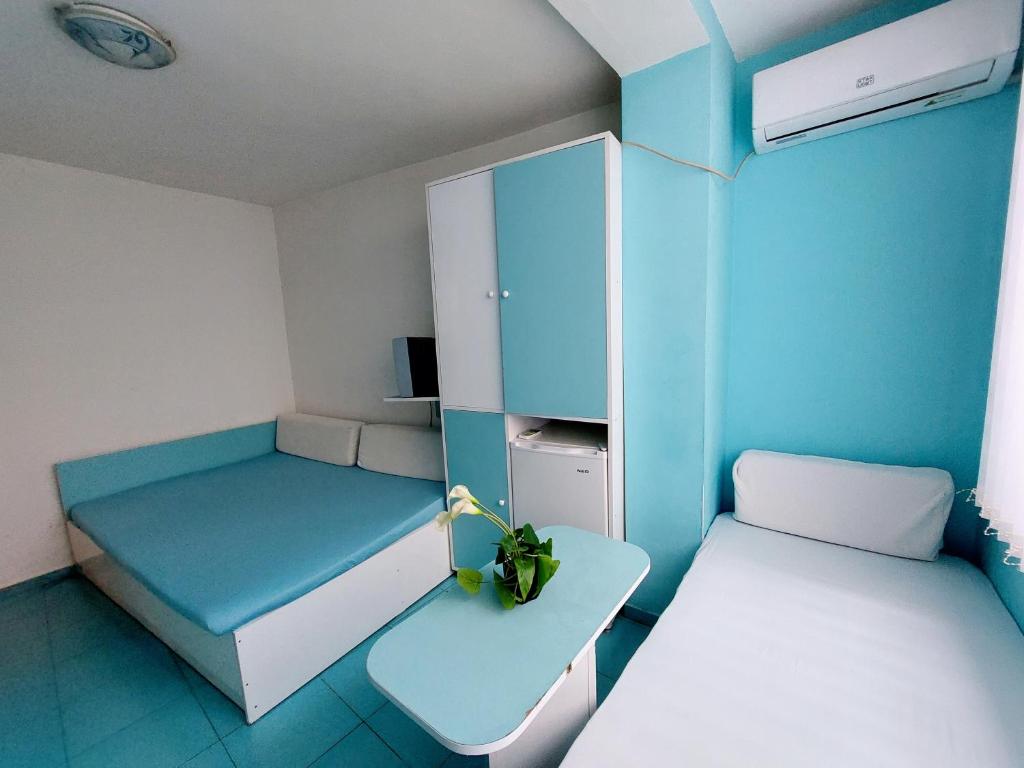 a small room with two beds and a refrigerator at APARTMENT LEO 3 in Varna City