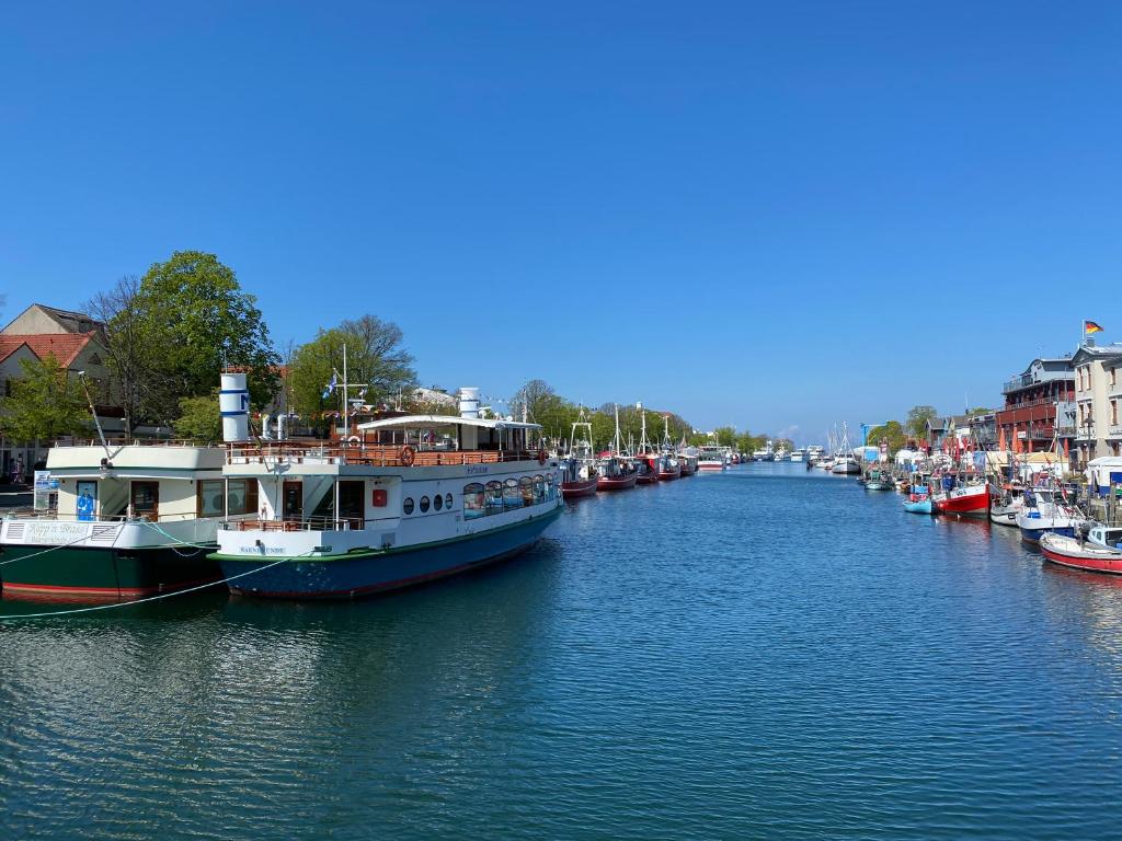 a group of boats are docked in a river at Hostel, Gästehaus zum Molenfeuer in Warnemünde