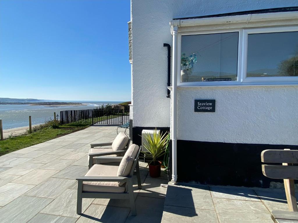 a group of chairs sitting next to a building at Seaview Cottage in Aberdyfi