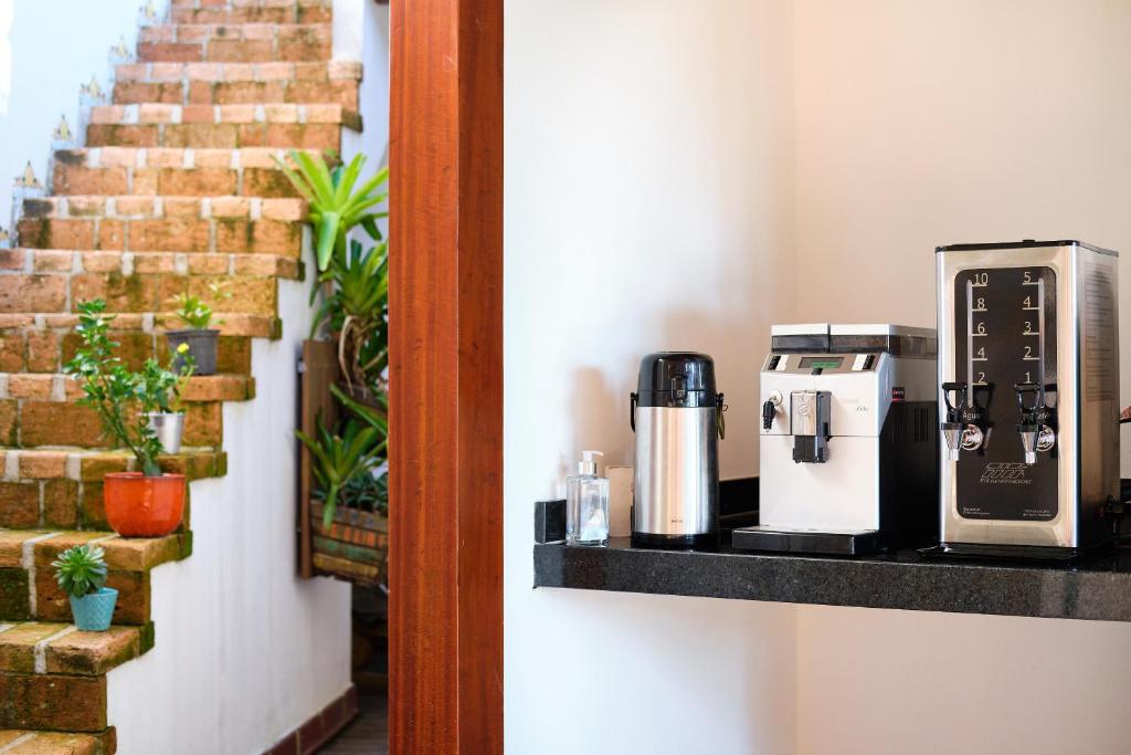 a coffee maker on a shelf next to a staircase at Boutique Hotel Carpe Diem in Paraty