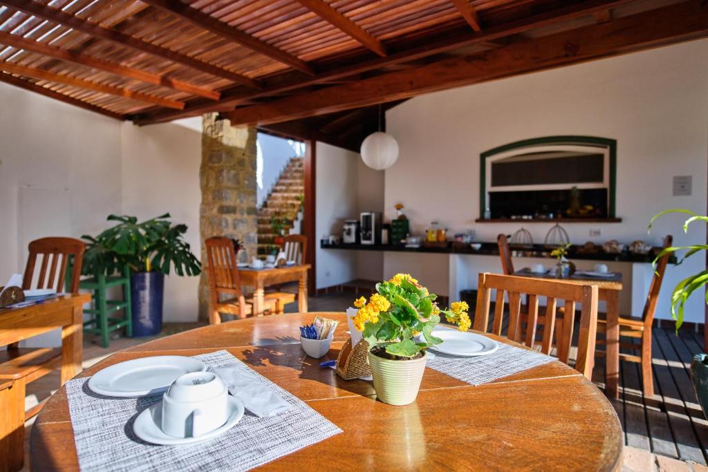 a wooden table with plates and flowers on it at Boutique Hotel Carpe Diem in Paraty