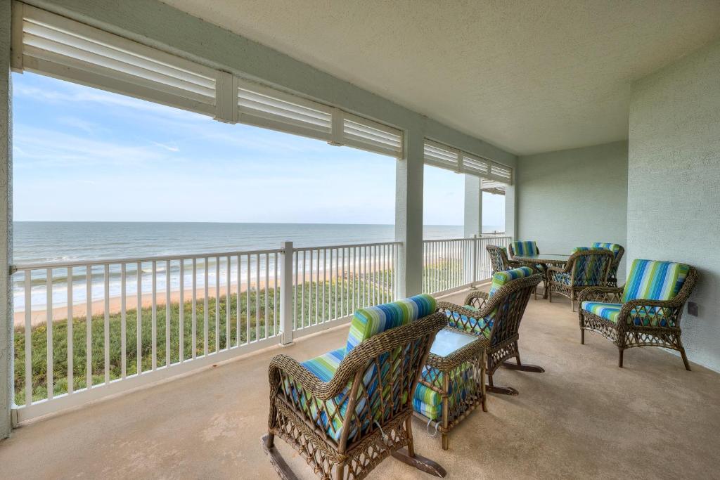 a room with chairs and a balcony with a view of the ocean at 851 Cinnamon Beach, 3 Bedroom, Sleeps 6, Ocean Front, 2 Pools, Elevator in Palm Coast