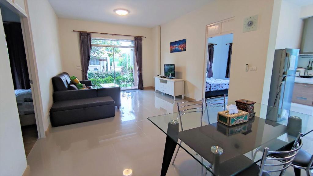 - un salon avec une table en verre et un canapé dans l'établissement Happy house @ Casa Seaside Rayong, à Ban Chak Phai