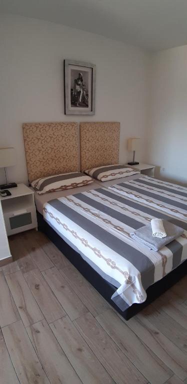 a large bed in a bedroom with a wooden floor at Rooms Lami in Dubrovnik