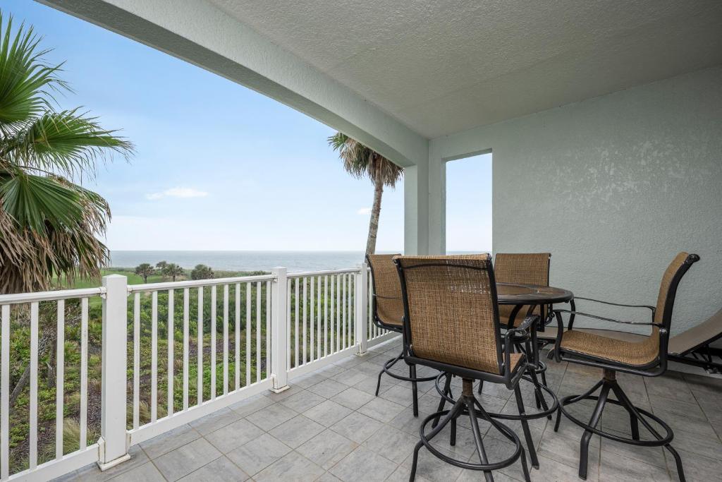 a balcony with a table and chairs and the ocean at Cinnamon Beach La Bonne Vie, 3 Bedroom, Sleeps 8, Ocean View, 2 Pools, Pet Friendly in Palm Coast