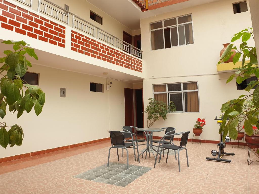 un patio con tavolo e sedie di fronte a un edificio di Hatun Wasi Huaraz a Huaraz