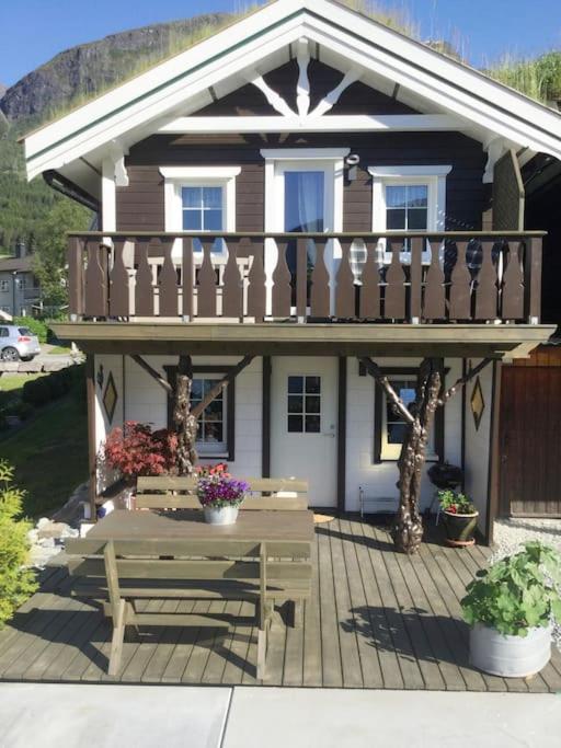 a small house with a deck and a bench at Fjordgaestehaus in Innfjorden