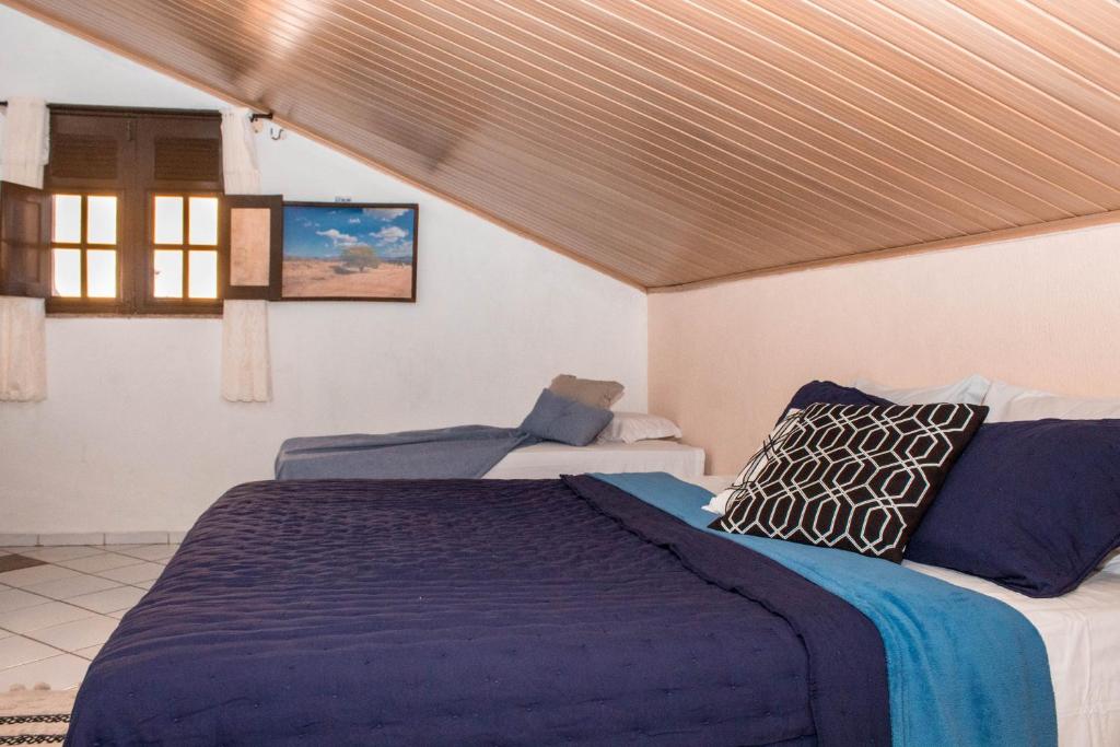 um quarto com uma cama grande e uma janela em Pousada Cogumelos em Guaramiranga