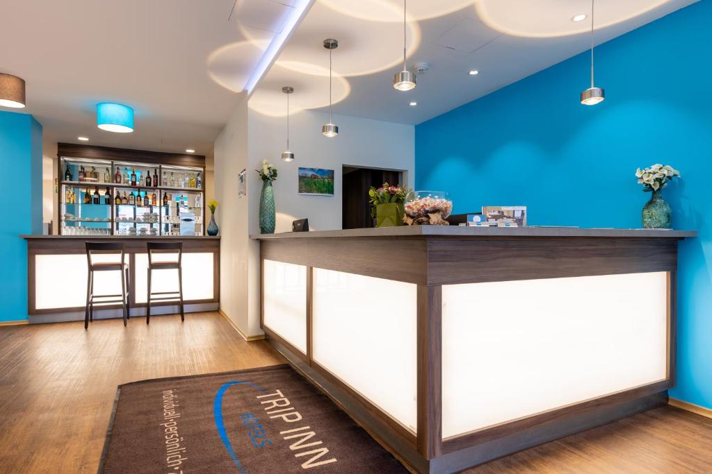 a bar in a restaurant with blue walls at Trip Inn Hotel Münster City in Münster